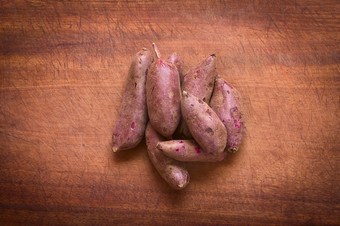 开销拍摄生紫色的甜蜜的土豆年番薯拉木董事会拍摄与自然光