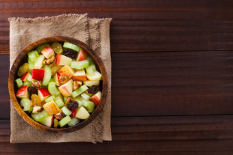 新鲜的华尔道夫酒店沙拉使芹菜苹果核桃小葡萄干和葡萄干木碗拍摄开销与复制空间的一边华尔道夫酒店沙拉