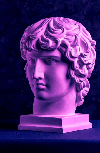 石膏复制著名的古老的雕像安提诺乌斯头黑暗变形背景石膏古董雕塑年轻的男人。脸文艺复兴时期的时代紫色的健美的石膏复制古老的著名的雕像安提诺乌斯头黑暗变形背景石膏古董雕塑年轻的男人。脸文艺复兴时期的时代紫色