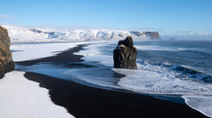 全景图像的沿海景观角迪霍莱冬天一天与白雪覆盖的海岸线冰岛