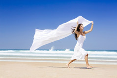 美丽的女孩的海滩运行和持有白色一块织物