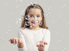 可爱的小女孩玩与肥皂泡沫
