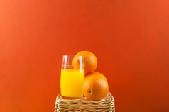 玻璃橙色汁和橙子柳条篮子