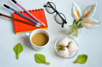 浪漫的桌子上与点缀从手工制作的产品莉莉花针织从白色纱手册针织铅笔咖啡杯眼镜美丽的工艺