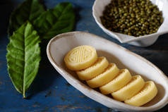 越南甜蜜的食物绿色豆子蛋糕从绿色小扁豆传统的食物为茶时间板食物杯茶木背景