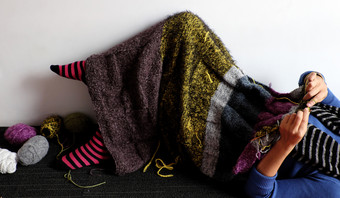 亚洲女人说谎地板上首页针织羊毛毯子为温暖的冬季针织爱好休闲活动使手工制作的礼物照片女人手工作从前面视图一天