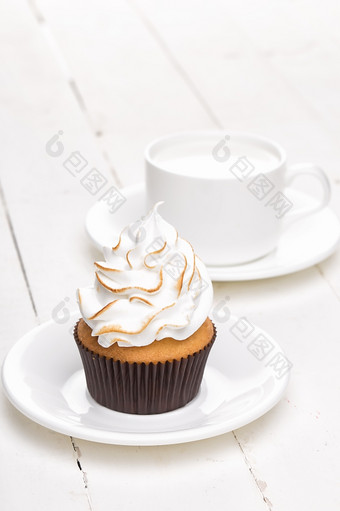 纸杯蛋糕与白色奶油与杯白色木表格纸杯蛋糕与白色奶油与杯