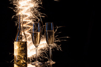 庆祝活动香槟的火花孟加拉灯黑色的背景的概念的庆祝活动的婚礼和的新一年复制空间庆祝活动香槟的火花孟加拉灯