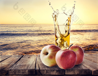 玻璃苹果汁与苹果木表格背景海景观玻璃苹果汁与苹果木表格
