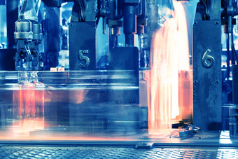 过程运动热玻璃瓶输送机热红色的瓶移动沿着的输送机的玻璃工厂爽肤水过程运动热玻璃瓶输送机