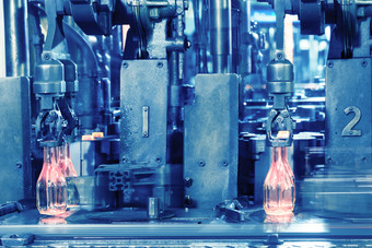 的热玻璃瓶输送机是使的玻璃制造商热红色的瓶移动沿着的输送机的工厂爽肤水的热玻璃瓶输送机是使的玻璃汇率政策