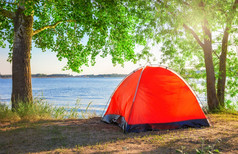 红色的旅游帐篷的湖下的明亮的太阳夏天红色的旅游帐篷湖下明亮的太阳夏天
