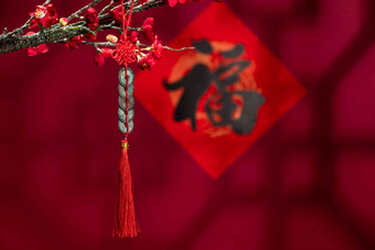 悬挂在梅花下面的中国结
