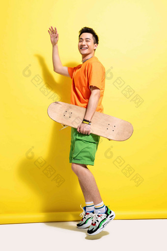 拿着滑板的快乐青年男人