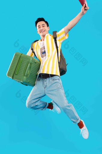 抱着行李箱去旅行的年轻男人