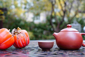 户外桌子上摆放的柿子和茶具