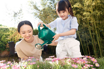 年轻的母亲和女儿在浇花