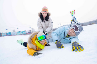 快乐的一家三口在雪地上打滚玩耍