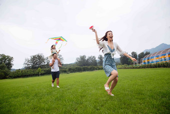 快乐的一家三口在草地上放风筝