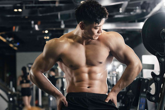 年轻男子在健身房展示肌肉