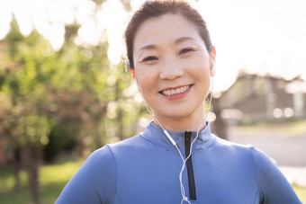 户外健身的中年女子听音乐音乐高端摄影图