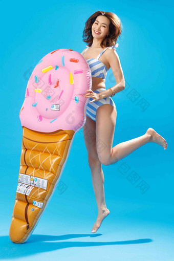 扶冰淇淋形状的浮排跳跃的比基尼美女