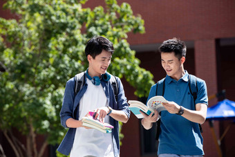 校园里边走路边探讨学习的年轻男子