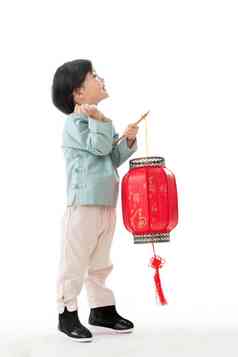 一个小男孩手提红色灯笼庆祝新年