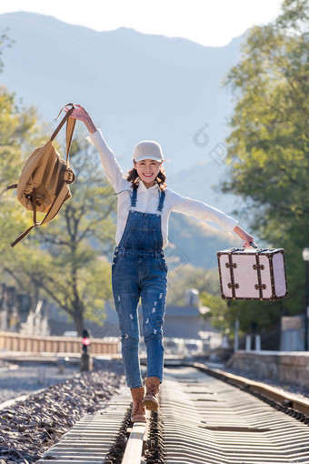 青年女人<strong>徒步走</strong>在铁轨上