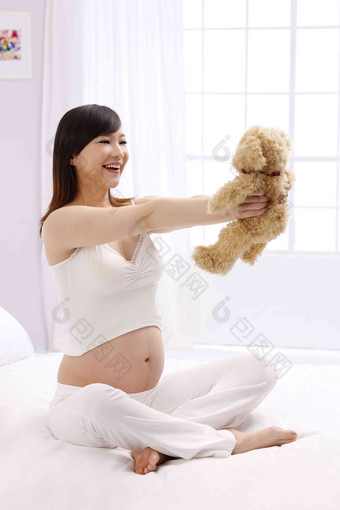 孕妇拿着<strong>玩具熊</strong>