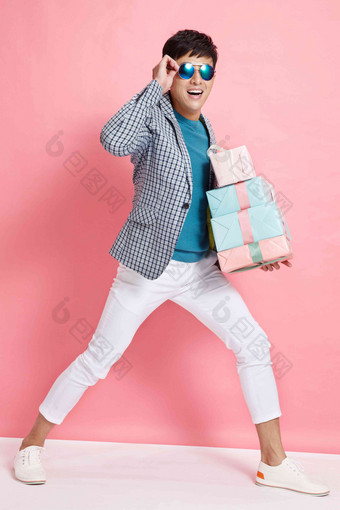 时尚年轻男人拿着礼盒