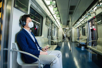 青年男子戴口罩乘坐地铁