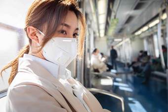 年轻女人戴口罩坐地铁