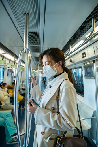 戴口罩的年轻女人乘坐<strong>地铁</strong>