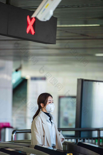 戴口罩的年轻女人走进地铁站