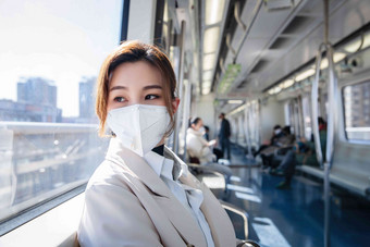 戴口罩的年轻女人乘坐地铁