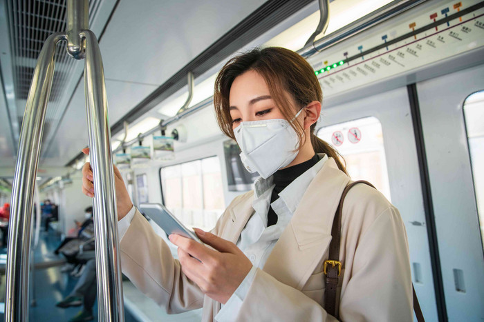 青年女人在地铁上看手机商务人士高清素材