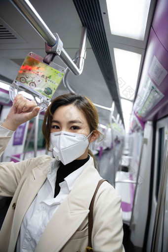 戴口罩的年轻女人乘坐地铁