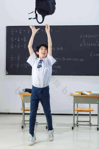 快乐的小学男生在教室里欢呼跳跃