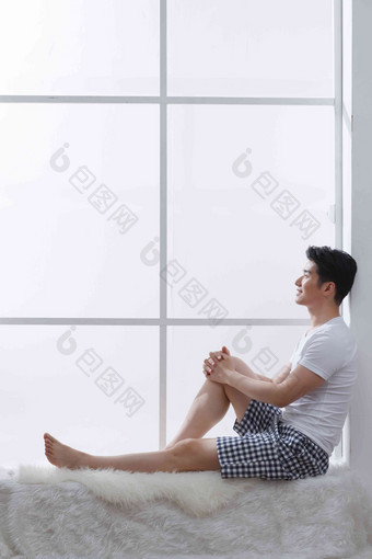 青年男人坐在窗户旁边