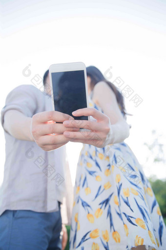 青年情侣用手机照相