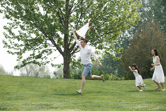 一家三口在草地上放风筝