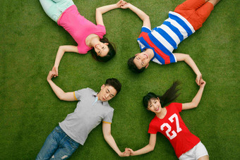 青年男女躺在草地上玩耍