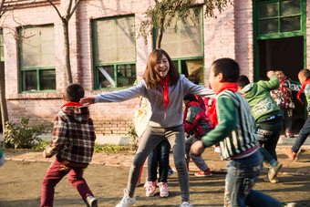 乡村教师和小学生在学校里做游戏