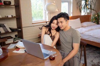 青年夫妇在家使用电脑