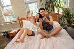 青年情侣趴在床上玩手机