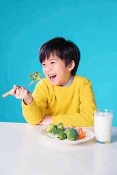 快乐的小男孩吃蔬菜