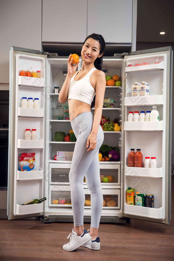 穿着运动装的青年女人站在冰箱前