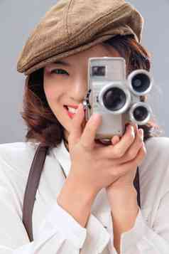 年轻女孩拿着古典式照相机