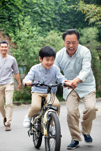 爷爷协助孙子骑自行车